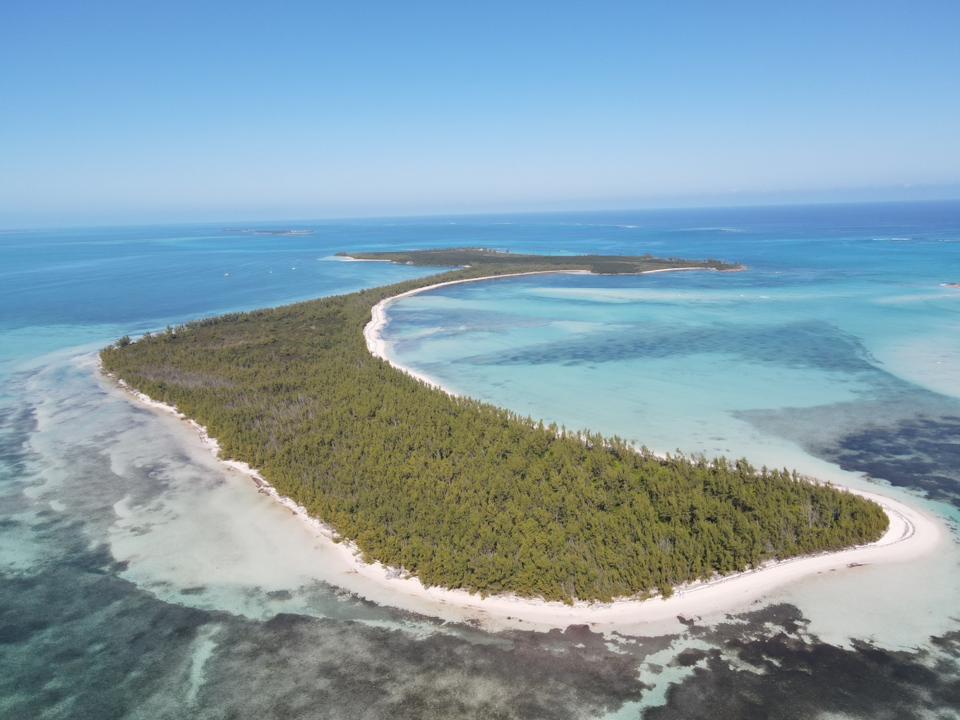 Aerial view of Powell Cay showing the full island surrounded by turquoise waters